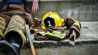 Person, brown, yellow, firefighter suit seating, concrete, ground ...